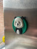 3D-geprinte panda koelkastmagneet met groene achtergrond.